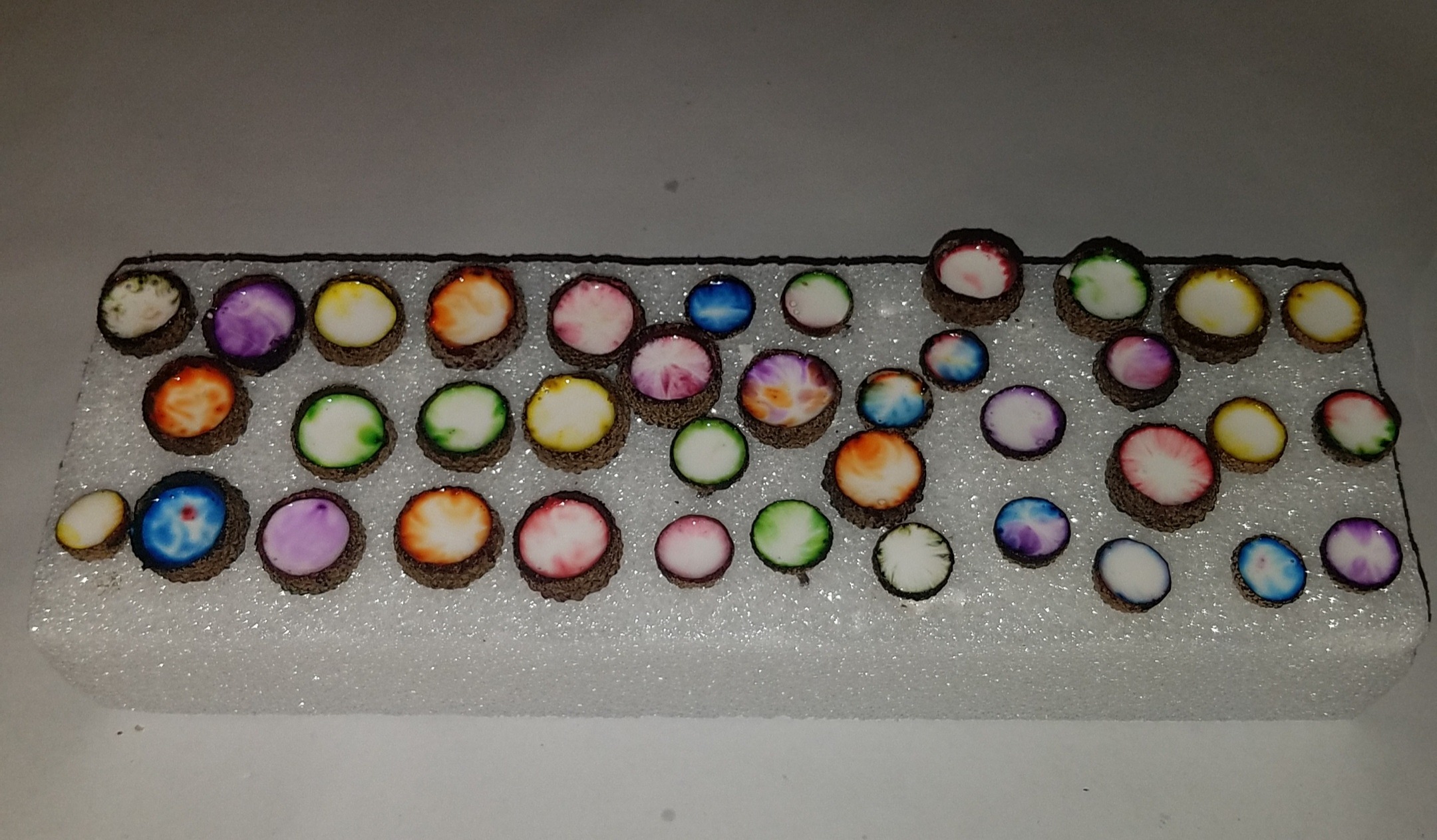Colored acorn caps filled with glue turning different colors